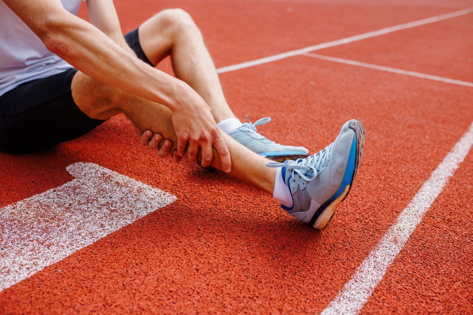 athlete-holding-his-leg-injured-after-running-at-t-2024-07-02-20-42-35-utc